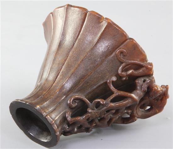 A Chinese rhinoceros horn libation cup, 17th century, width 9.7cm height 9.5cm length 12.6cm, losses to handle and small rim chips